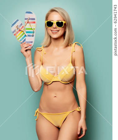 woman in yellow bikini and sunglasses with woman in yellow bikini and sunglasses with 62941743