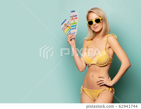 woman in yellow bikini and sunglasses with woman in yellow bikini and sunglasses with 62941744
