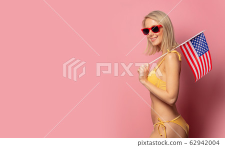 woman in yellow bikini and sunglasses with USA woman in yellow bikini and sunglasses with USA 62942004