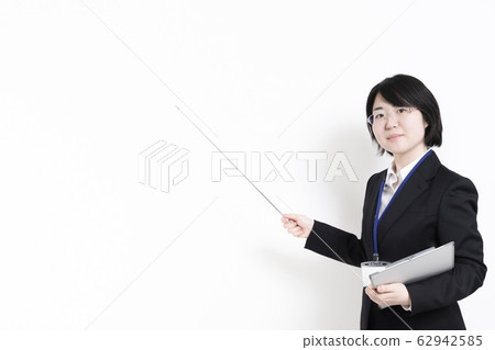 A woman in a suit pointing to a point 62942585