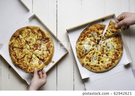 Taking pizza slices from pizza boxes. Two cheese 62942621