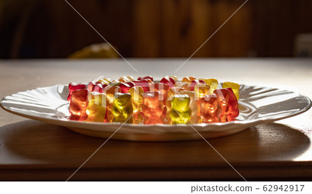 Colorful Transparent Jelly Bears on white plate side view Colorful Transparent Jelly Bears on white plate side view 62942917