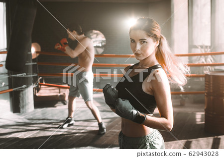Female boxer doing shadow boxing inside a boxing ring. Boxer practicing her moves at a boxing studio. Female boxer doing shadow boxing inside a boxing ring. Boxer practicing her moves at a boxing studio. 62943028