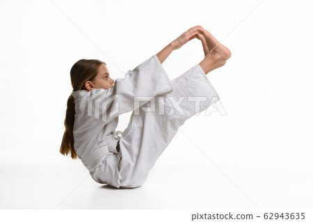 A girl in a sports kekogi reaches her hands at her 62943635