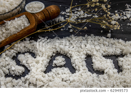 The salt crystals on black stone plate background. 62949573