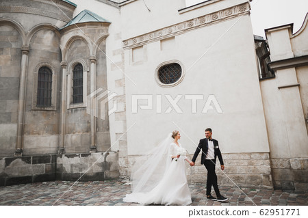 A loving wedding couple are walking back along the streets of the city of Lviv 62951771