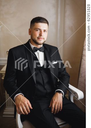 Young handsome man relaxing at his apartment in a hotel after business meeting Young handsome man relaxing at his apartment in a hotel after business meeting 62951828