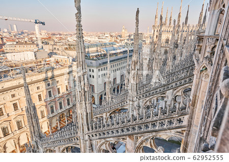 Amazing view of old Gothic spires. Milan Cathedral roof on sunny day, Italy. Milan Cathedral or Duomo di Milano is top tourist attraction of Milan. Amazing view of old Gothic spires. Milan Cathedral roof on sunny day, Italy. Milan Cathedral or Duomo di Milano is top tourist attraction of Milan. 62952555