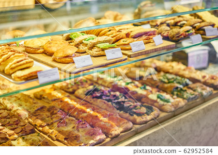 Croissant with ham and cheese. Hot pastries lie on the shelf in the cafe. Buns and bagels in the store. Croissant with ham and cheese. Hot pastries lie on the shelf in the cafe. Buns and bagels in the store. 62952584