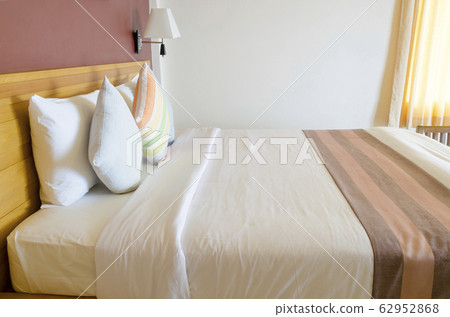 Colourful Pillow on bed. 62952868