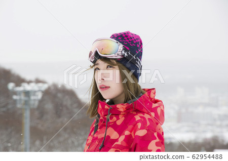 Ski slope and female skier who flutter light snow Ski slope and female skier who flutter light snow 62954488