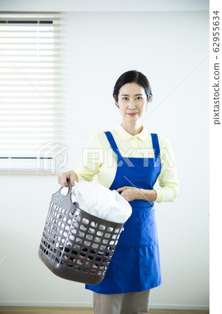 Housewife, middle and old aged with laundry basket Housewife, middle and old aged with laundry basket 62955634