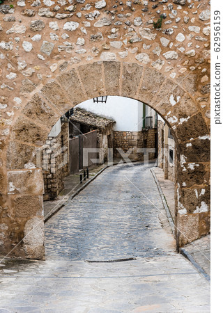 Street and stone arch in the medieval town of Pastrana in Spain 62956159