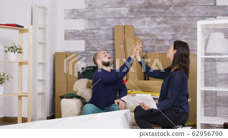 Couple assembling furniture int heir new apartment Couple assembling furniture int heir new apartment 62956790