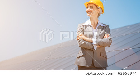 Woman investor in clean energy standing in front of solar panels Woman investor in clean energy standing in front of solar panels 62956974