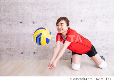 Women playing volleyball (receive with a smile) 62960155