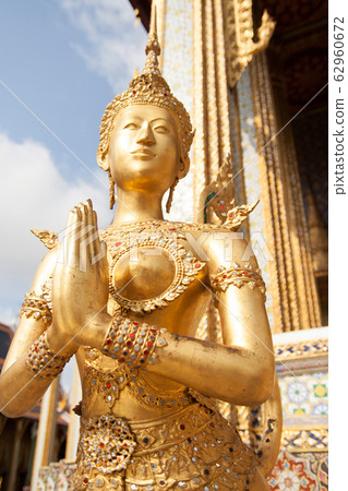 Golden Kinnari statue at Temple of Emerald Buddha (Wat Phra Kaew) in Grand Royal Palace. Kinnari creature at south-east Asian Buddhist mythology. Wat Phra Kaew is popular famous tourist attraction in  62960672