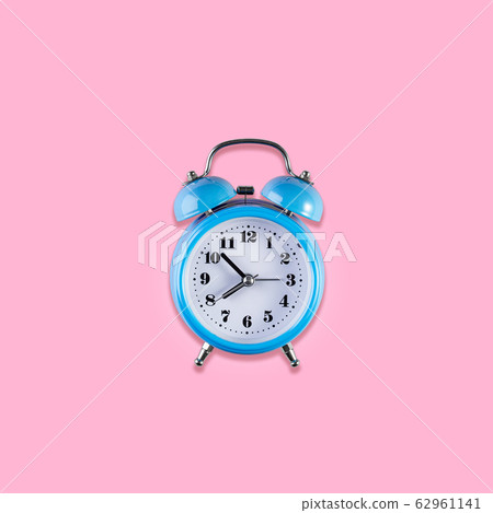 Blue vintage alarm clock on light pink color Blue vintage alarm clock on light pink color 62961141