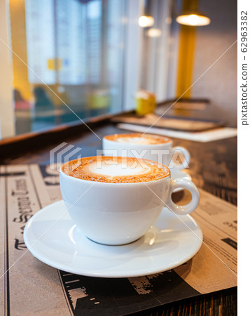 Two cups of cappuccino on a table in a cafe. drawing heart on Latte coffee froth. Delicious coffee for breakfast 62963382