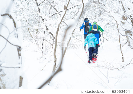 Parents and children enjoying snowshoes 62963404