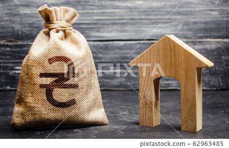 Ukrainian hryvnia UAH symbol money bag and house. Real estate purchase and investment. Affordable loan, mortgage. Taxes, rental income. rent or buy. Home budget. Maintenance of a residential building. Ukrainian hryvnia UAH symbol money bag and house. Real estate purchase and investment. Affordable loan, mortgage. Taxes, rental income. rent or buy. Home budget. Maintenance of a residential building. 62963485