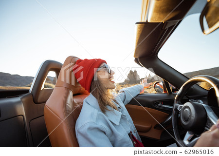 Woman traveling by cabriolet on the desert road 62965016