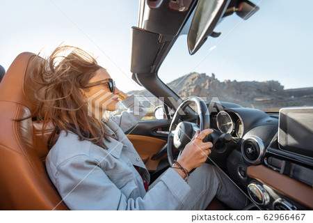 Woman traveling by cabriolet on the desert road 62966467