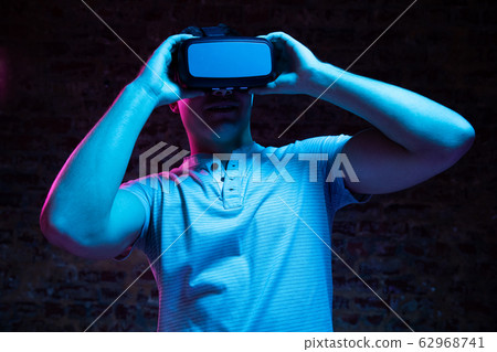 Caucasian man holding a Virtual Reality headset Caucasian man holding a Virtual Reality headset 62968741