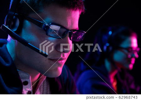 Caucasian man and a woman working late in an office Caucasian man and a woman working late in an office 62968743