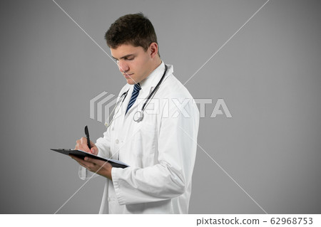 Caucasian male doctor on grey background 62968753
