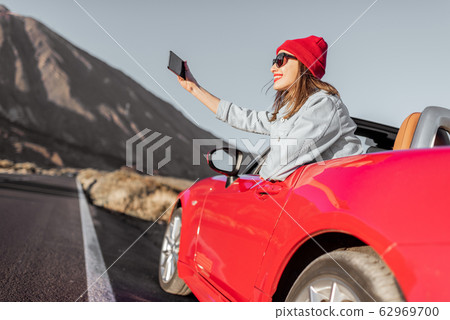 Happy woman traveling by car on the volcanic valley Happy woman traveling by car on the volcanic valley 62969700
