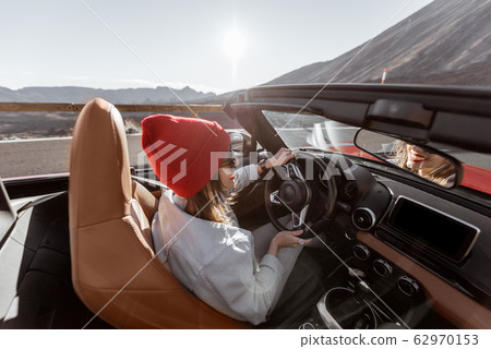 Woman traveling by cabriolet car on the desert road Woman traveling by cabriolet car on the desert road 62970153