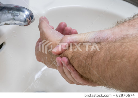 Man washing hands in basin close-up Man washing hands in basin close-up 62970674