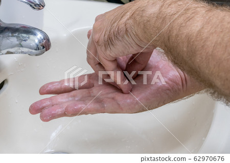Man washing hands in basin close-up Man washing hands in basin close-up 62970676
