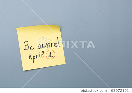 april fools day reminder on yellow sticky note. be aware and do not let be fooled 62972591