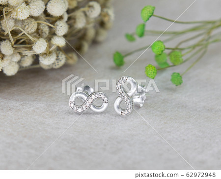 A pair of beautiful diamond earrings in the infinity shape 62972948