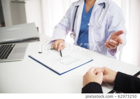 Female medicine doctor working on table with consulting patient Female medicine doctor working on table with consulting patient 62973250