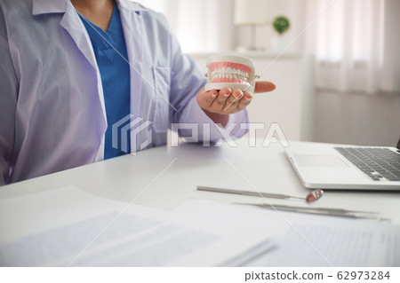 Female Dentist working in office 62973284