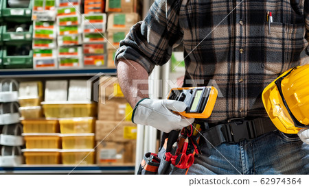 Electrician in the store of electrical components. Electrician in the store of electrical components. 62974364