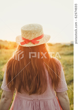 Young girl back up in a straw hat with a red Young girl back up in a straw hat with a red 62974693