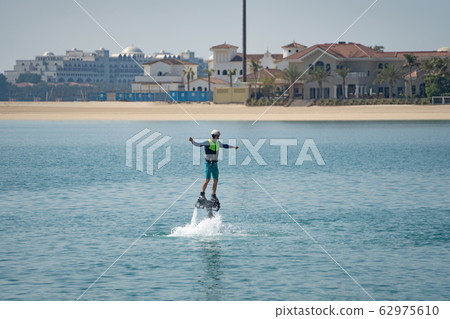 Water extreme sport. The guy is flying at the aquatic flyboard. Extreme rest on the sea 62975610