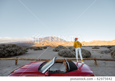 Woman traveling by car on the volcanic valley Woman traveling by car on the volcanic valley 62975642