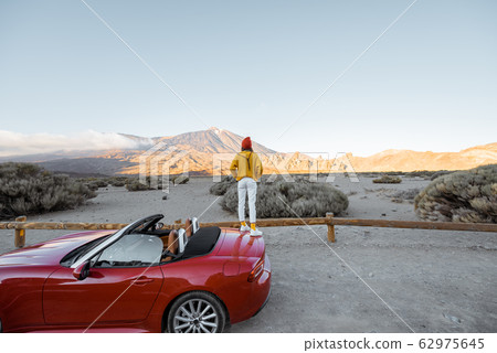 Woman traveling by car on the volcanic valley Woman traveling by car on the volcanic valley 62975645