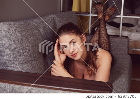 A young woman is resting lying on her stomach. 62975703