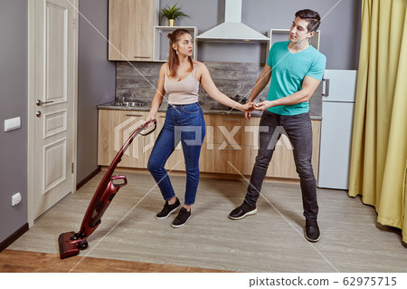 A white man distracts the woman from cleaning. A white man distracts the woman from cleaning. 62975715