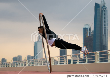 Cyr Wheel artist wearing black and white smart clothes with cityscape background of Dubai during Cyr Wheel artist wearing black and white smart clothes with cityscape background of Dubai during 62975761