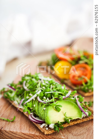 Avocado rye toasts with green herbs, onion and 62976155