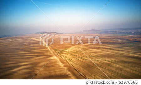 Aerial view of ploughed agricultural field. Dirt Aerial view of ploughed agricultural field. Dirt 62976566