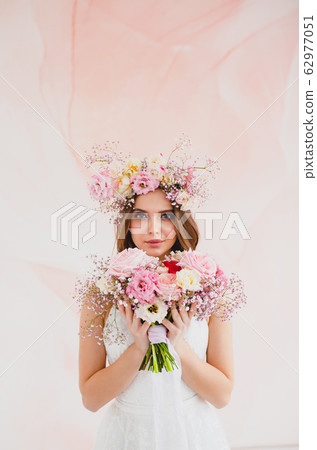 Portrait of beautiful bride with flower wreath on her head and bridal bouquet 62977051