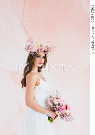 Portrait of beautiful bride with flower wreath on her head and bridal bouquet Portrait of beautiful bride with flower wreath on her head and bridal bouquet 62977062